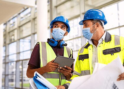 Construction workers in hard hats and masks