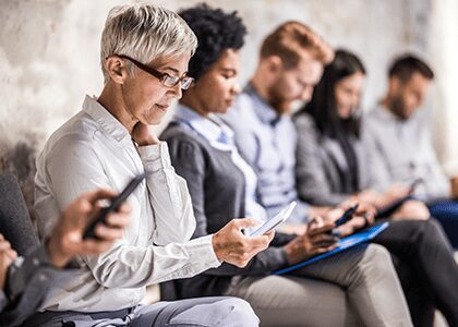 group of people waiting and looking at their devices