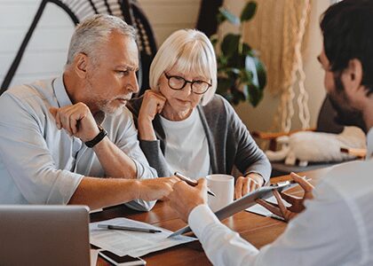 Couple signing paperwork with their financial advisor