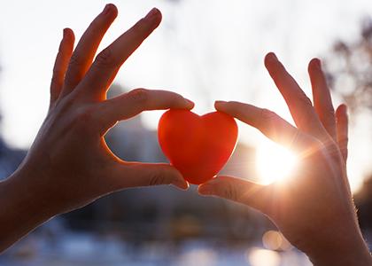 Hands holding heart up to light