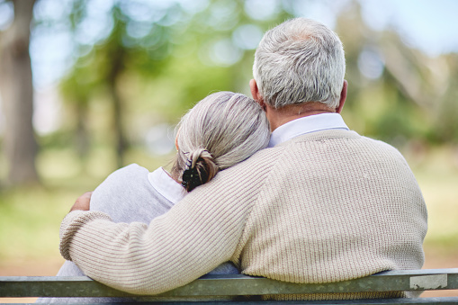 Couple snuggling on bench