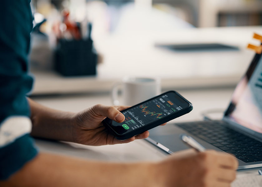 Hands holding a smartphone showing stocks